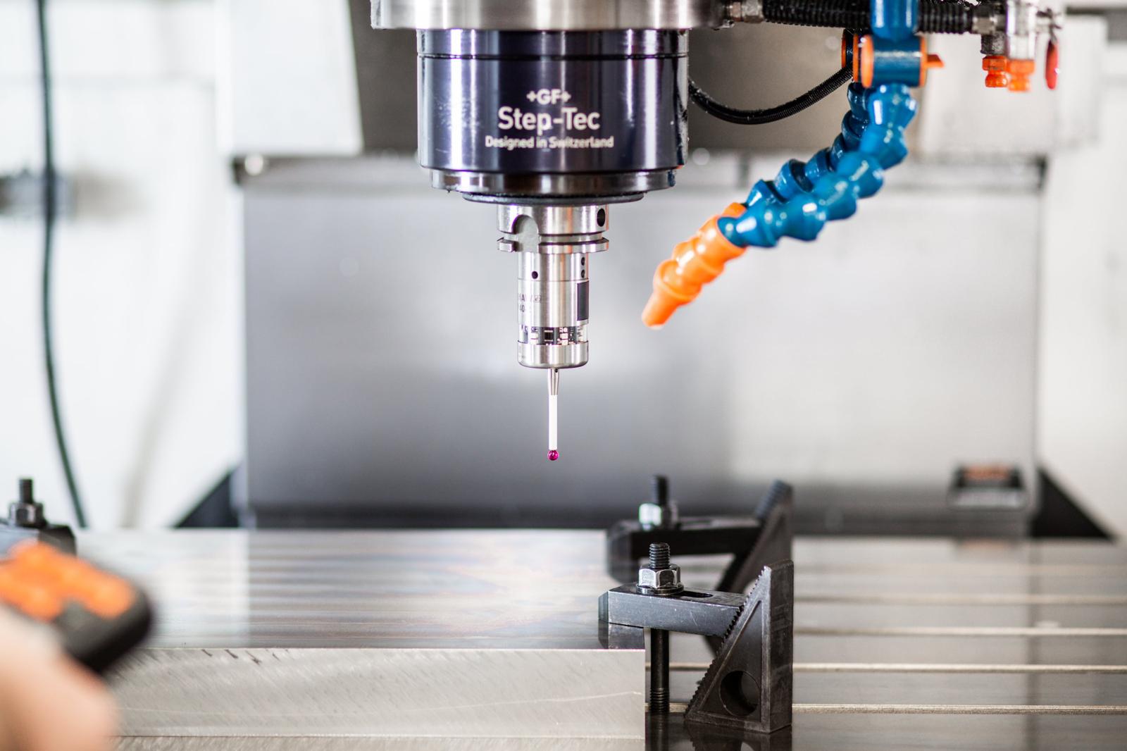 CNC machine cutting metal with blue coolant flowing