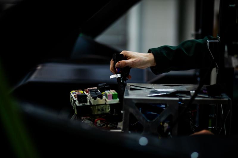 Detail of hands working on a wiring assembly at DASIS