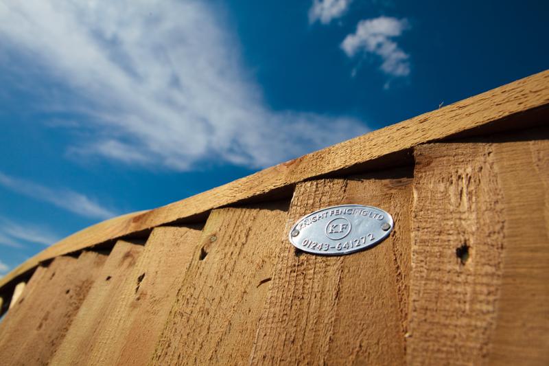 Knight Fencing timber post with a metal cap against a blue sky