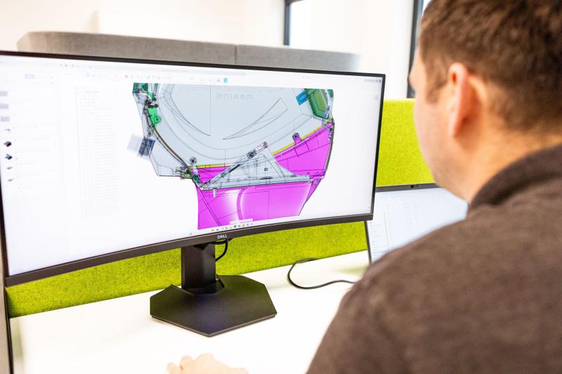 DASIS engineer reviewing a colourful CAD simulation on a monitor