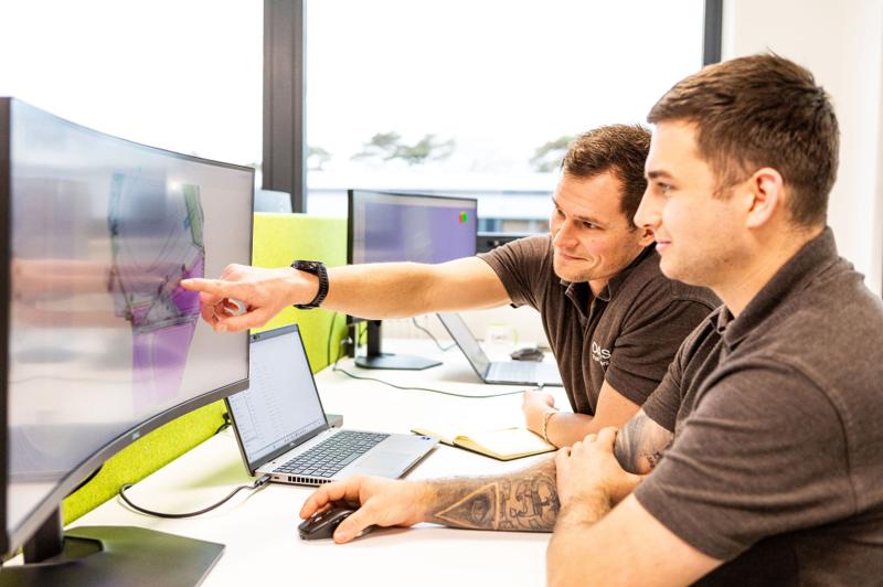 Two DASIS engineers reviewing CAD work on dual monitors