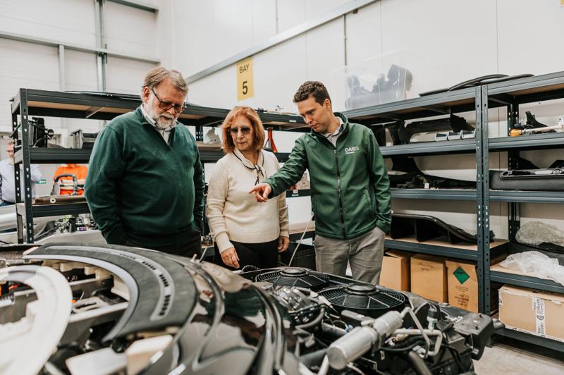 DASIS team and visitors gathered around a vehicle chassis in the workshop