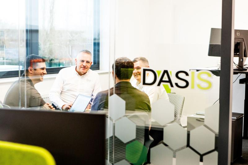 DASIS team meeting in an office booth beneath the DASIS sign