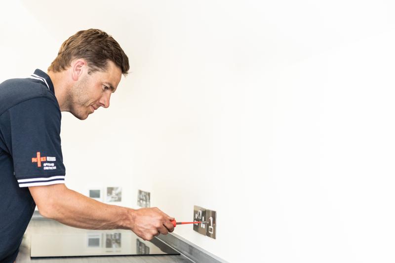 Engineer working on an electrical installation on a wall panel