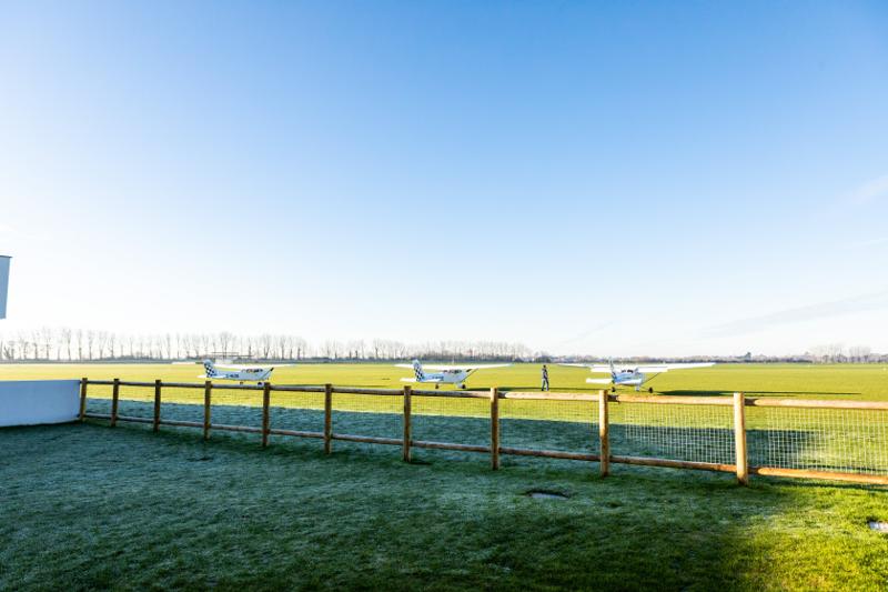 Knight Fencing post-and-rail fence line running across a green field