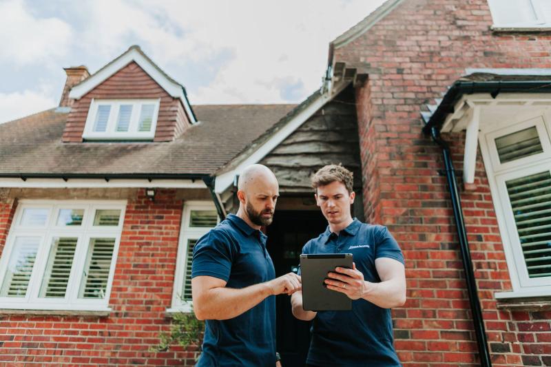 Two Pallant Surveyors team members conducting a property survey with a tablet