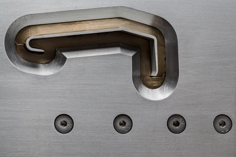 Close-up of a polished aluminium extrusion die tool