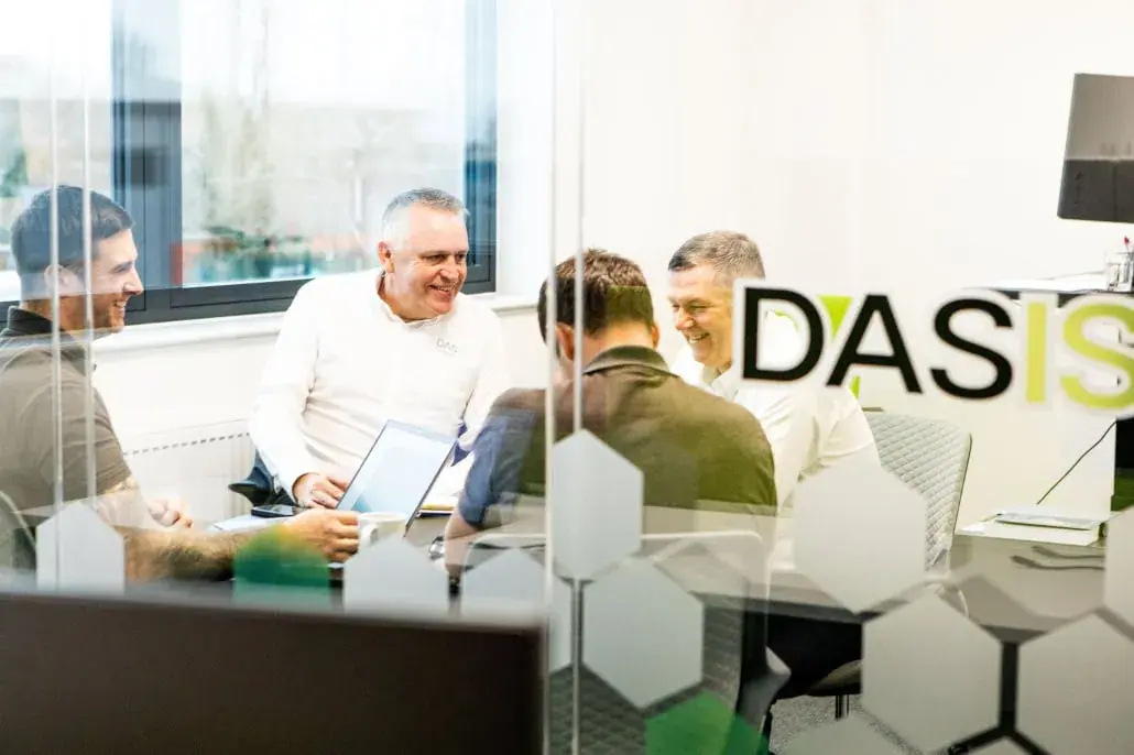 Boardroom meeting at DASIS beneath the DASIS sign