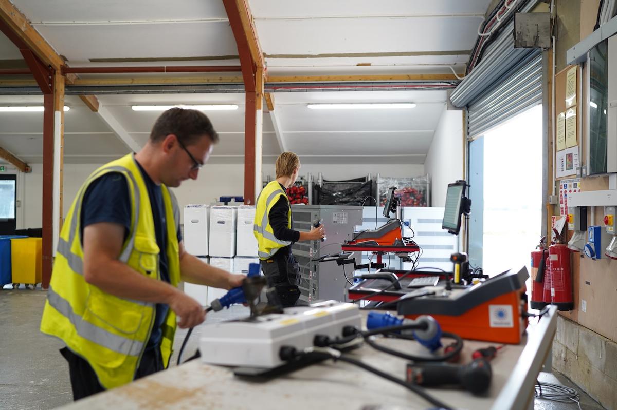 Heatload engineers in hi-vis preparing data centre testing equipment in the workshop