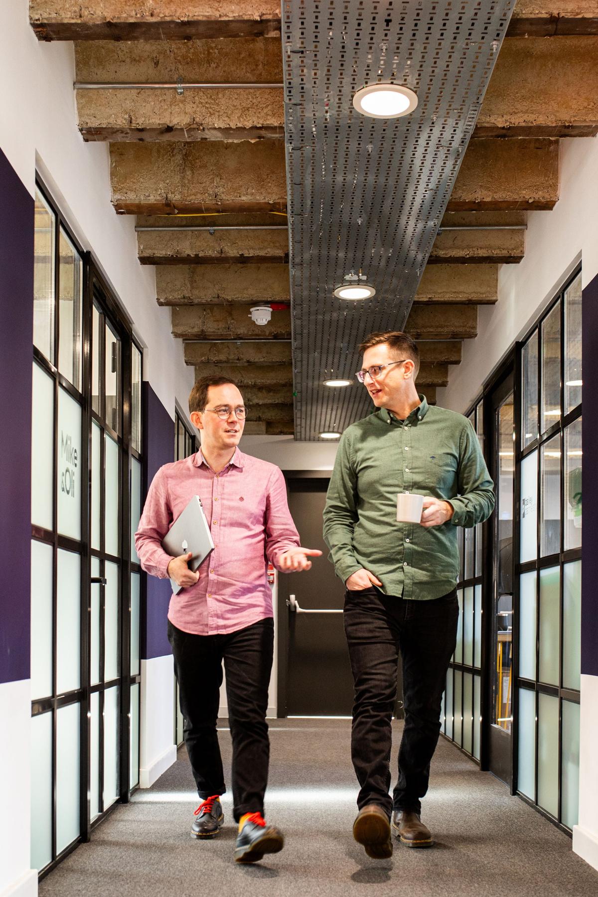 Pallant colleagues walking and talking in the studio corridor
