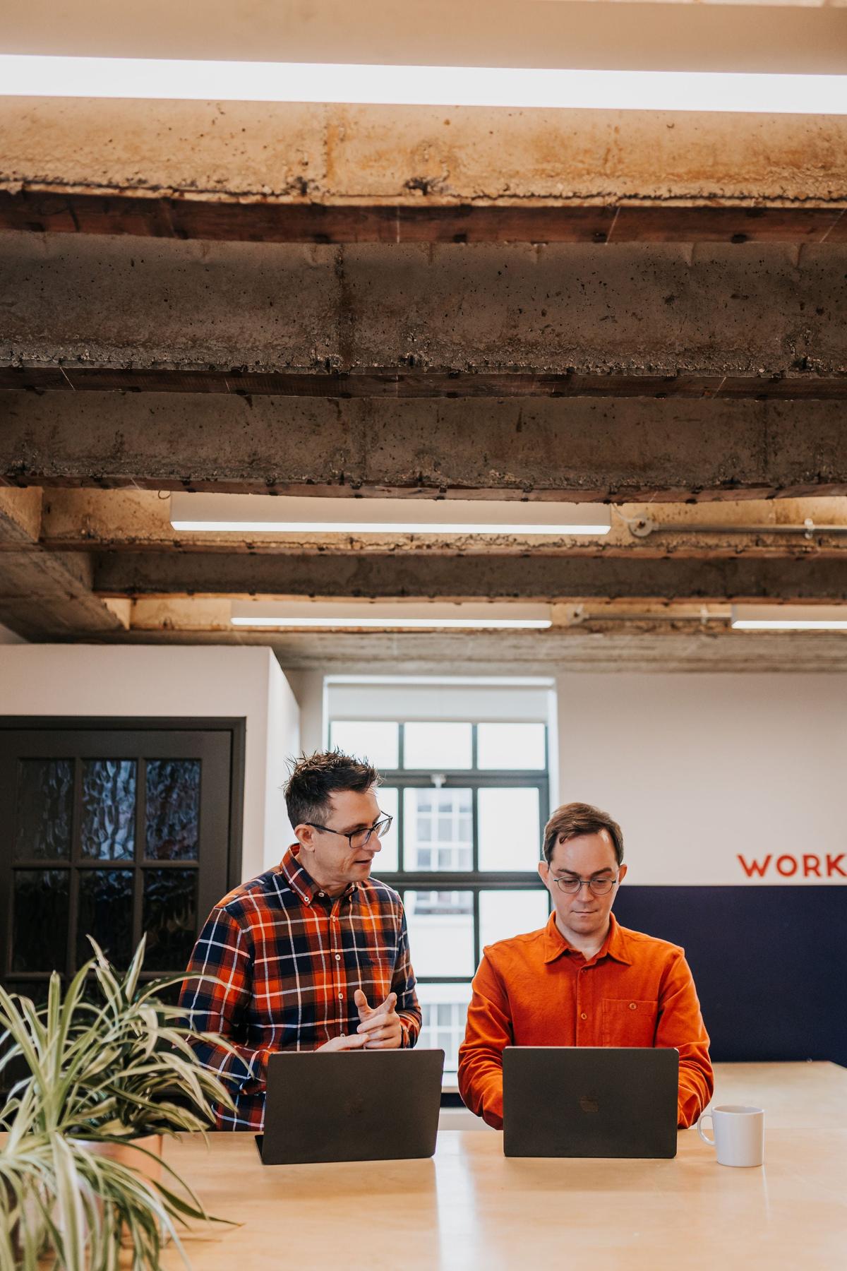 Two Pallant colleagues working at a desk in the studio