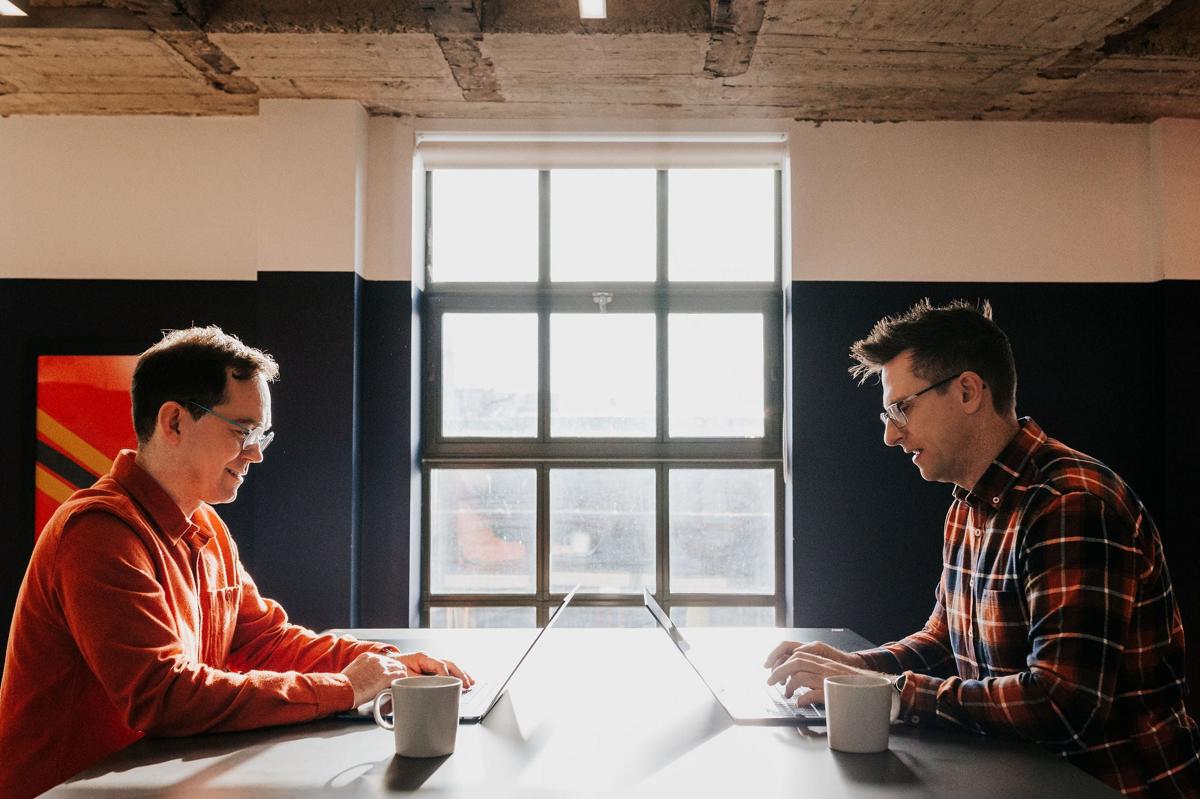 Two Pallant consultants working at a desk by the window