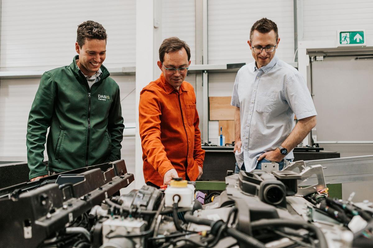 Pallant team and client reviewing engineered metal components in a workshop