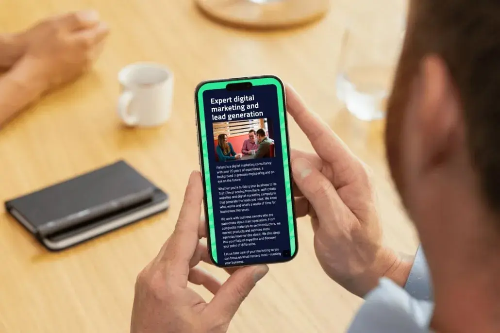 Pallant website article shown on a mobile phone held in hand